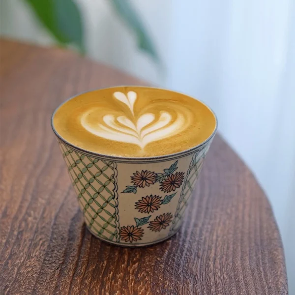 Marigold Handheld Ceramic Cup with Heart-Shaped Latte Art and Pink Chrysanthemum Design