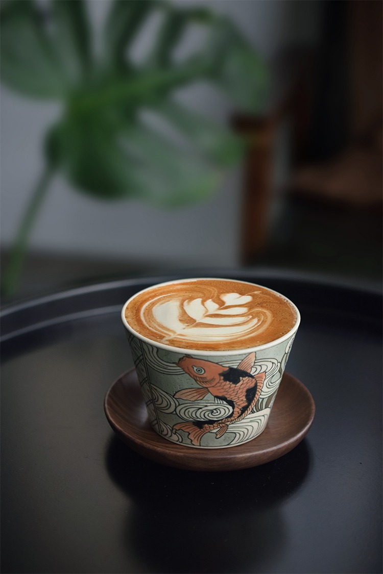 Hand-painted latte cup with blue-and-white koi fish for business professionals.