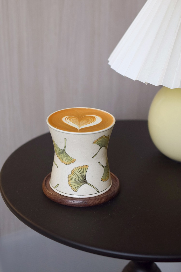 Handcrafted ceramic mug with vintage ginkgo leaf painting, designed for elegant modern home use.