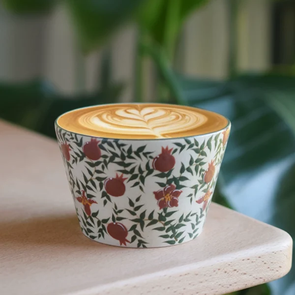 Nordic style ceramic cup with underglaze pomegranate flower pattern, perfect for enjoying coffee during travel