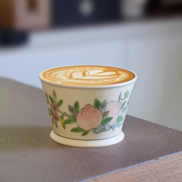 Hand-painted peach ceramic coffee cup with underglaze design, personalized and handcrafted, perfect for vintage style enthusiasts
