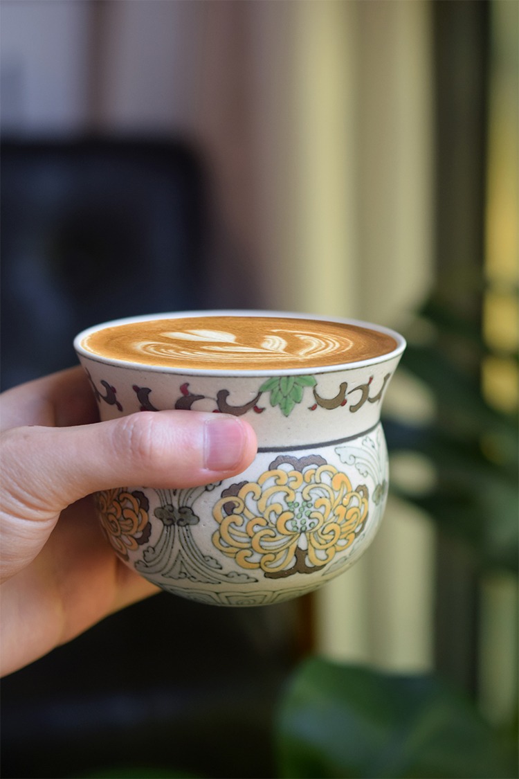 Hand-painted polychrome chrysanthemum ceramic coffee cup enjoying a sensory experience that combines taste and visual beauty