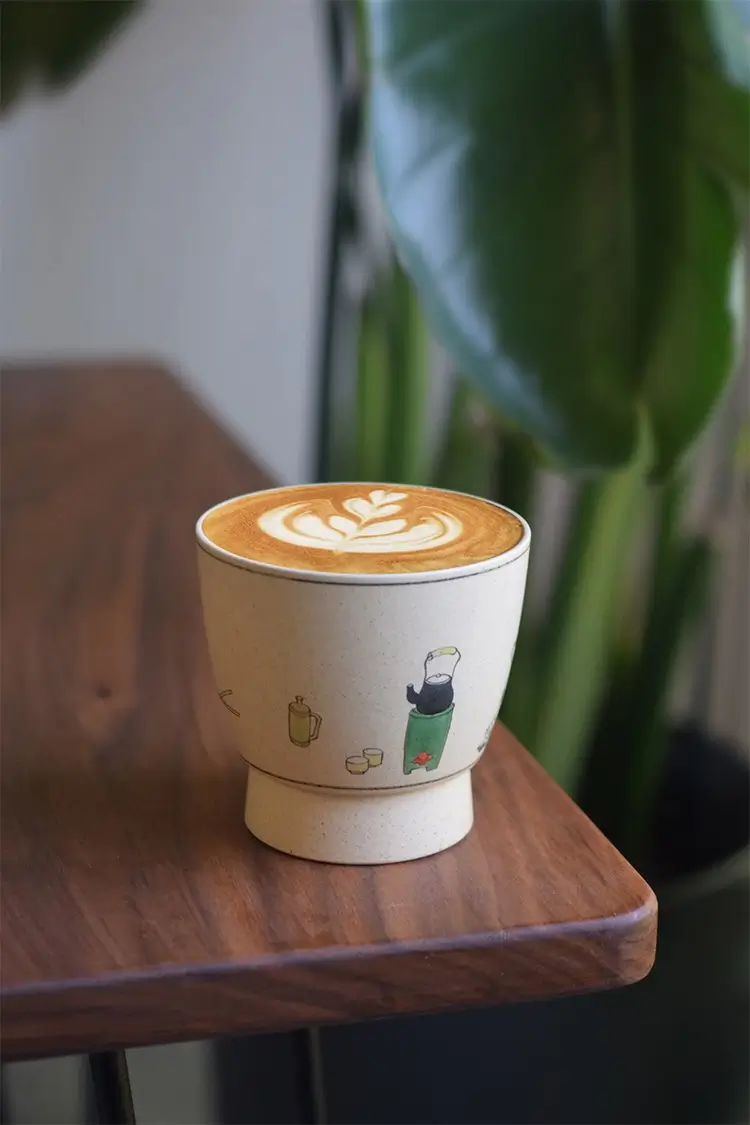 Artisan coffee mug features handmade ceramic body and hand-painted child and cat design for a warm, artistic touch
