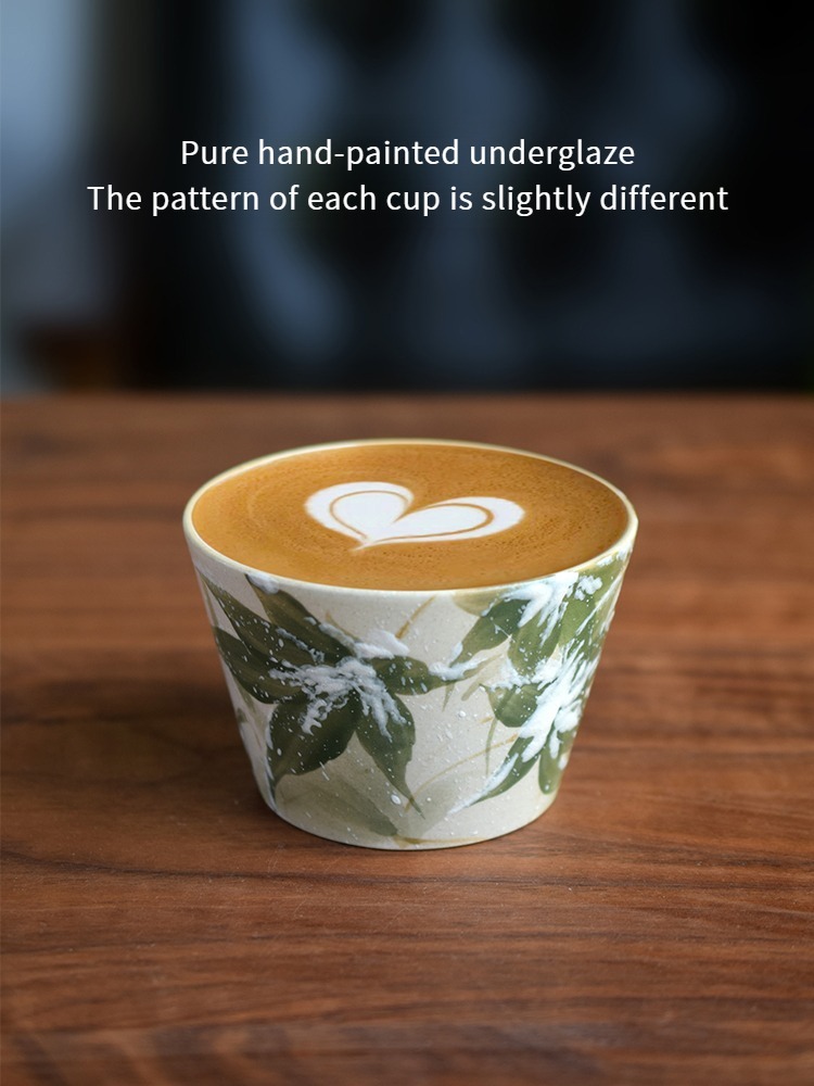Hand-painted ceramic coffee cup with snow bamboo motif in underglaze style, filled with warm coffee