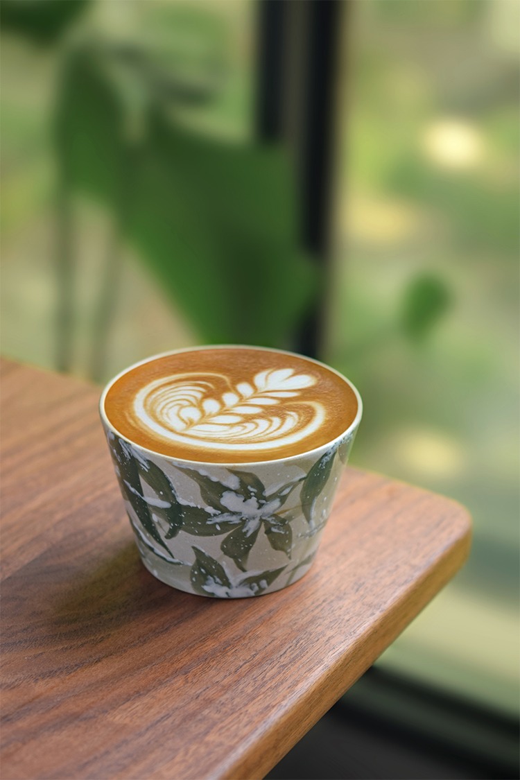Hand-painted ceramic coffee cup with snow bamboo underglaze design, smooth finish, placed on tabletop