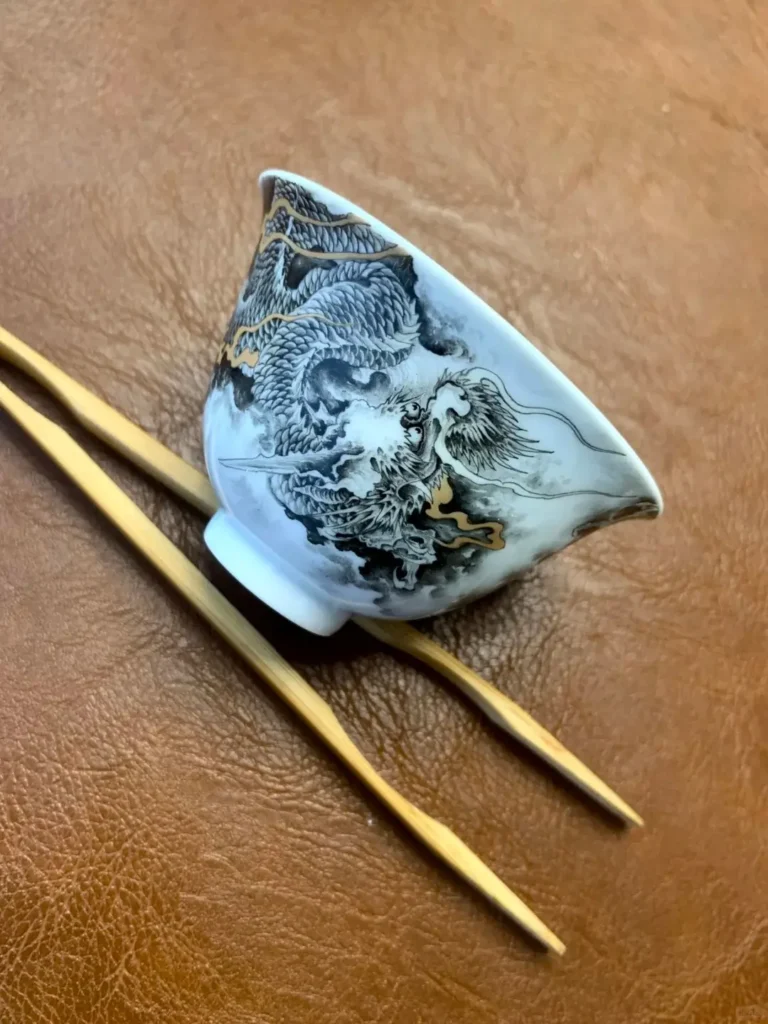 Imperial-style blue-and-white porcelain teacup with coiling dragon motif, hand-painted using 14th-century Jingdezhen techniques at Xiaogu Tang studio