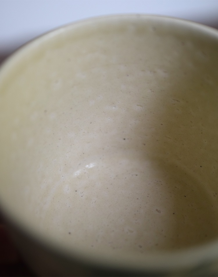 Inner glaze of hand-painted blue-and-white ceramic cup showing smooth finish and handmade texture.