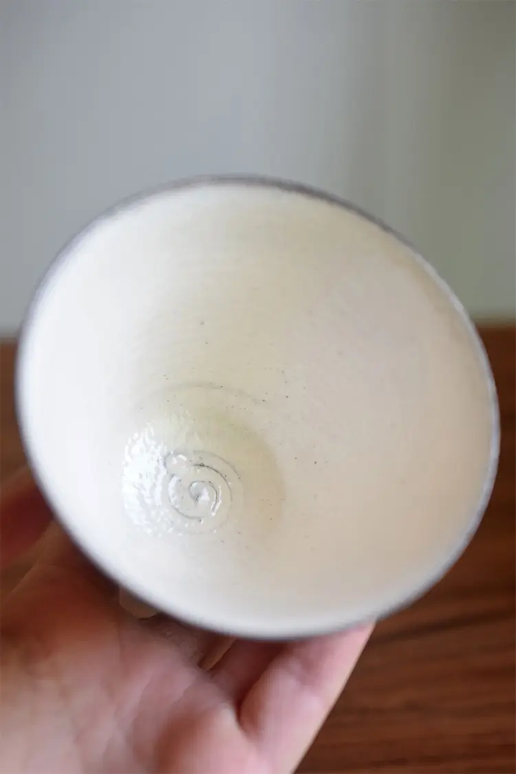 Custom coffee cup highlights handcrafted throwing lines, capturing the tactile beauty of traditional ceramic techniques.
