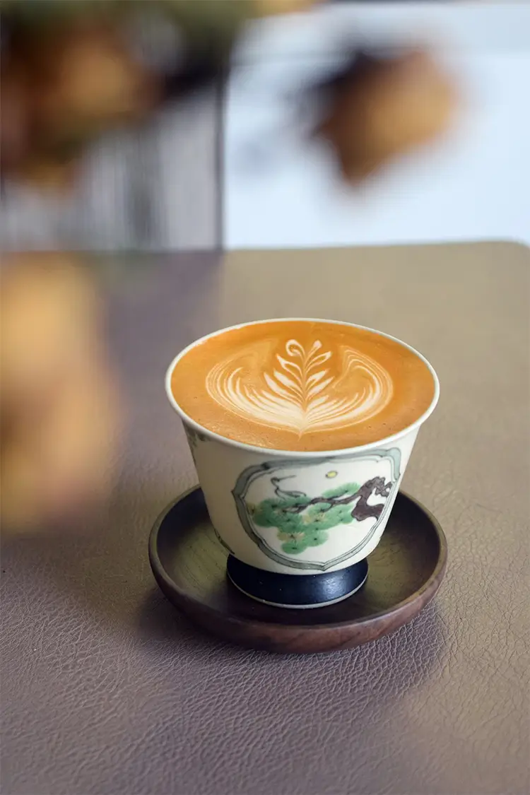 Custom coffee cup with pine and crane motif complements traditional Chinese-style café interiors.