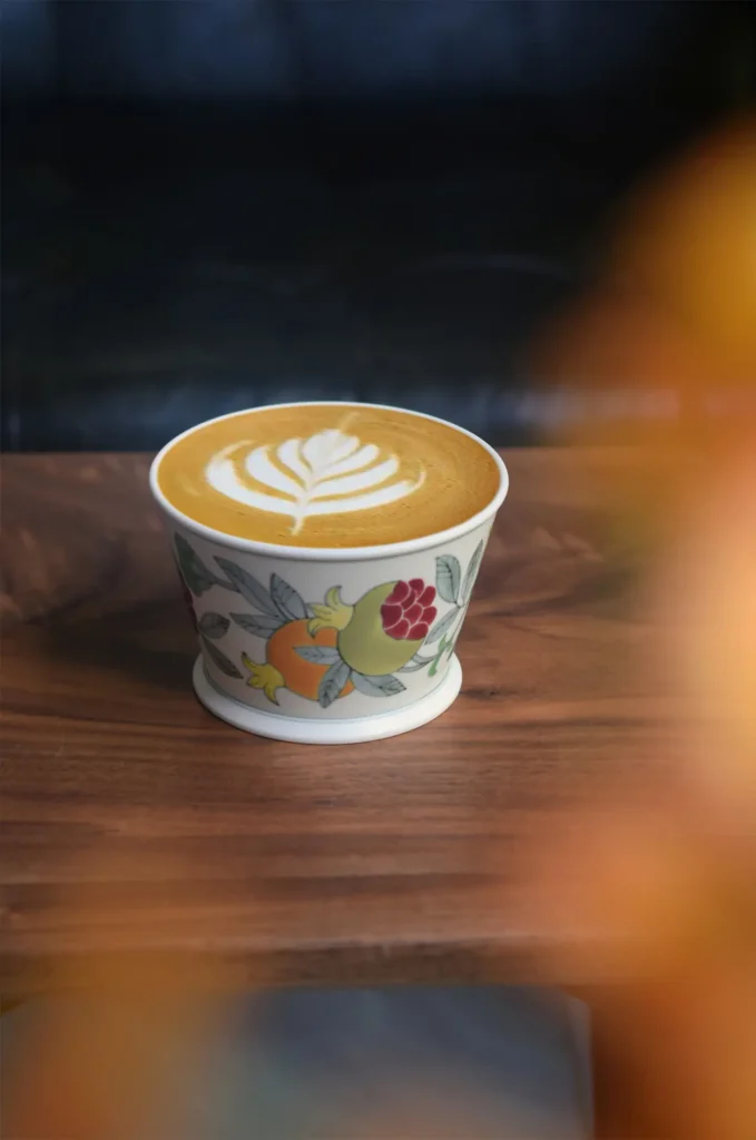 Customized coffee mug with underglaze pomegranate artwork elevates modern family dining aesthetics.