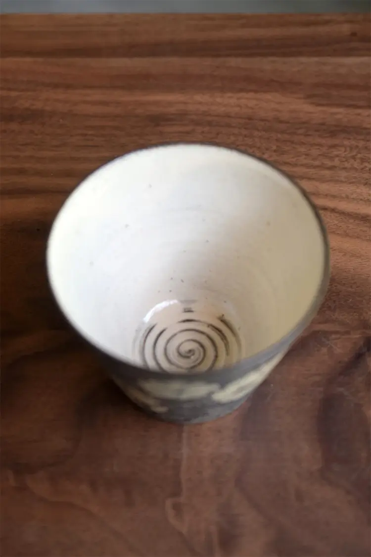 Hand-painted blue-and-white porcelain cup highlights thrown texture details, appealing to craft lovers with vintage artistry.