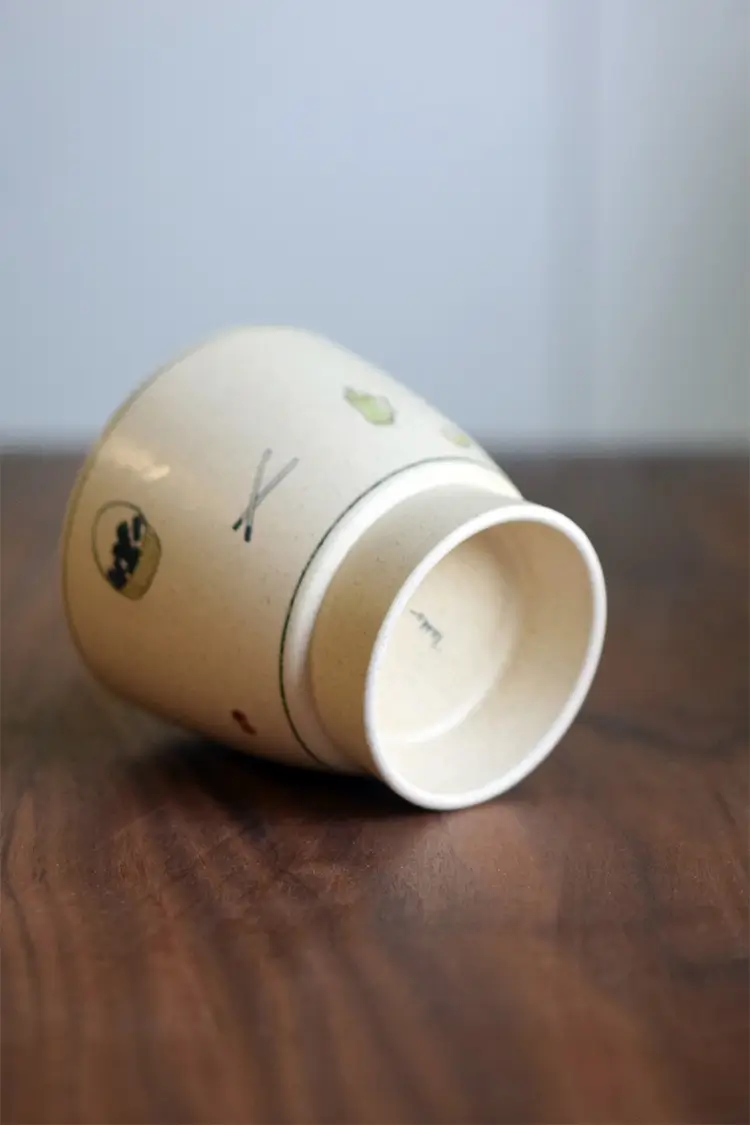 Handcrafted ceramic coffee mug features artist seal, perfect for enjoying your morning latte