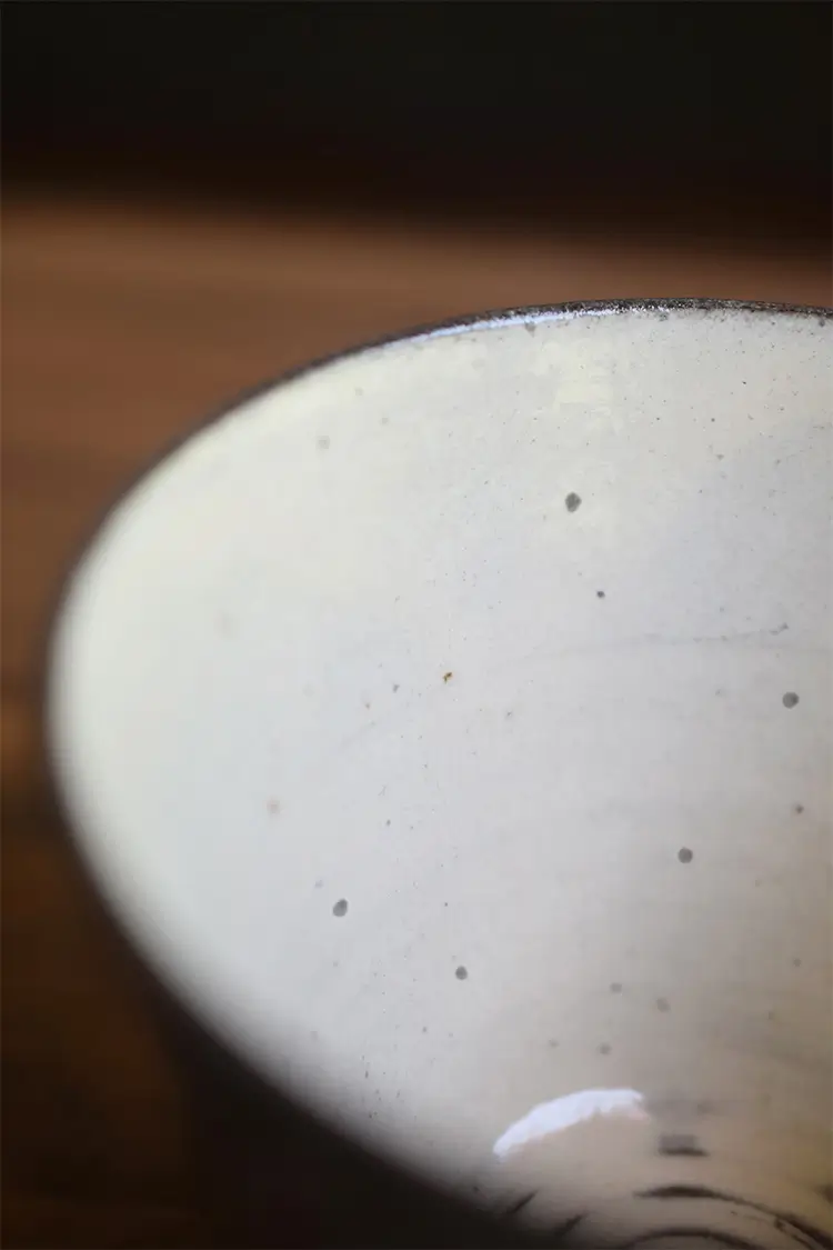 Handcrafted ceramic mug reveals unique making traces and visible iron specks for rustic authenticity.