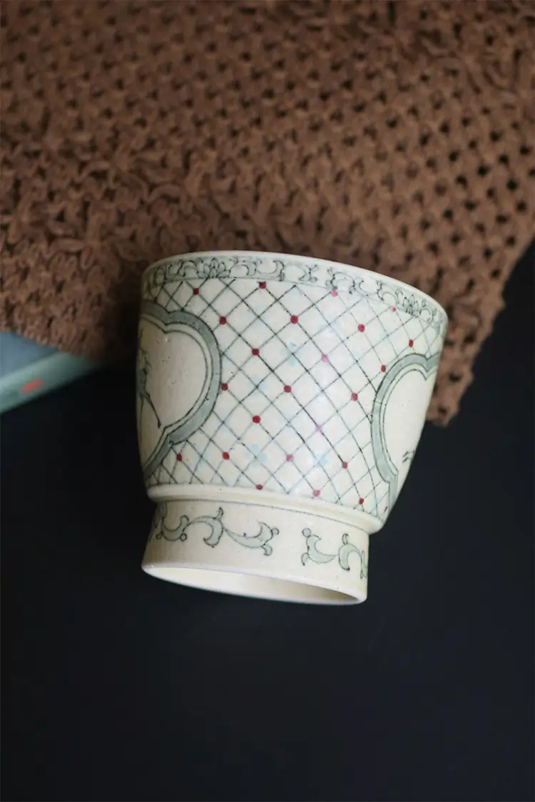 Handmade ceramic coffee cup displays elegant blue lattice pattern with traditional craftsmanship