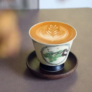 Handcrafted ceramic coffee cup showcases hand-painted pine and crane design, making it a meaningful birthday gift for elders.