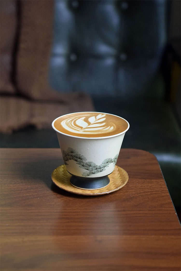 Handmade ceramic cup with pine tree design and elevated foot, ideal gift for elders.