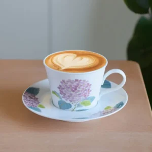 Handmade cup and saucer set featuring a purple hydrangea motif, ideal for everyday coffee use in modern homes.