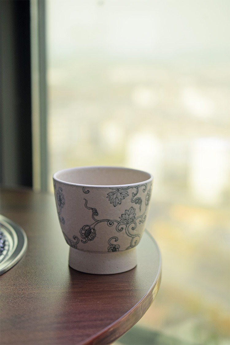 Hand-painted lychee texture ceramic tea cup placed on the table corner, favored by tea lovers.