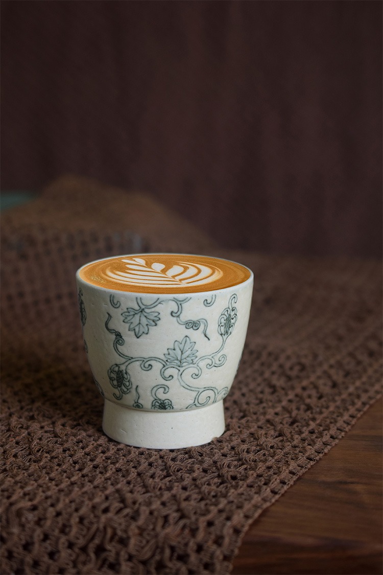 Latte served in a vintage Chinese-style ceramic coffee cup, enhancing café ambiance.
