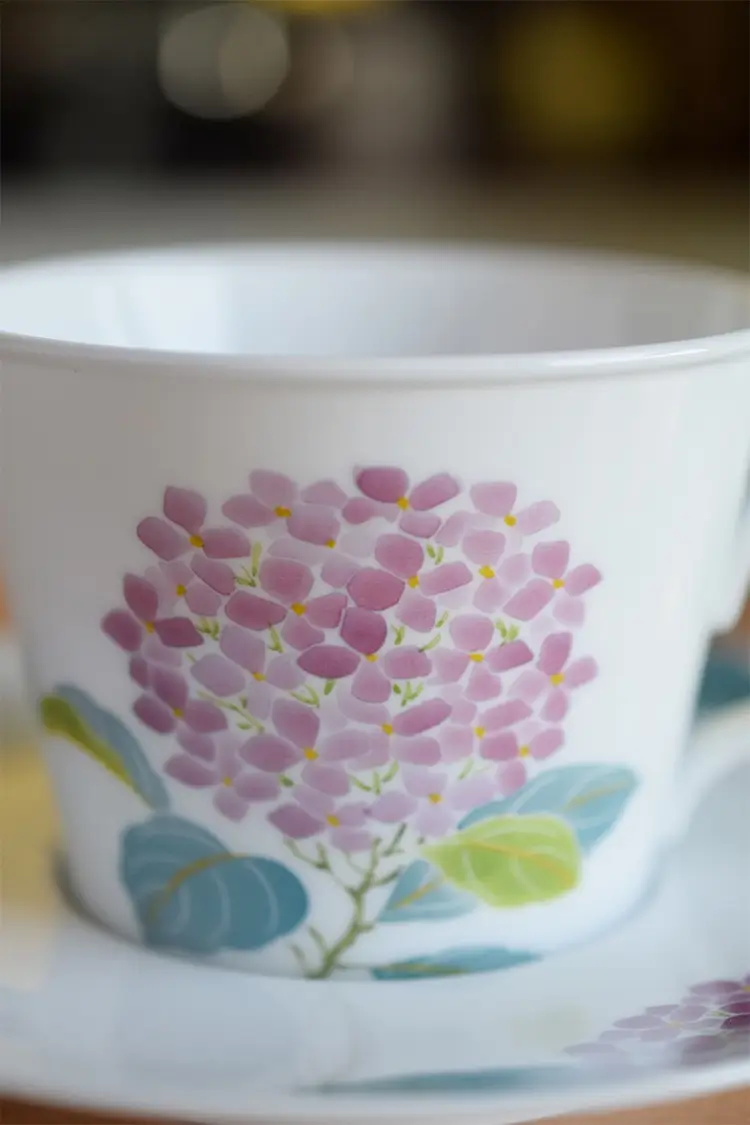 Hand-painted cup with purple hydrangea, ideal for your morning coffee.