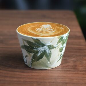 Hand-painted bamboo ceramic cup with floral latte art, rounded shape and soft glaze finish
