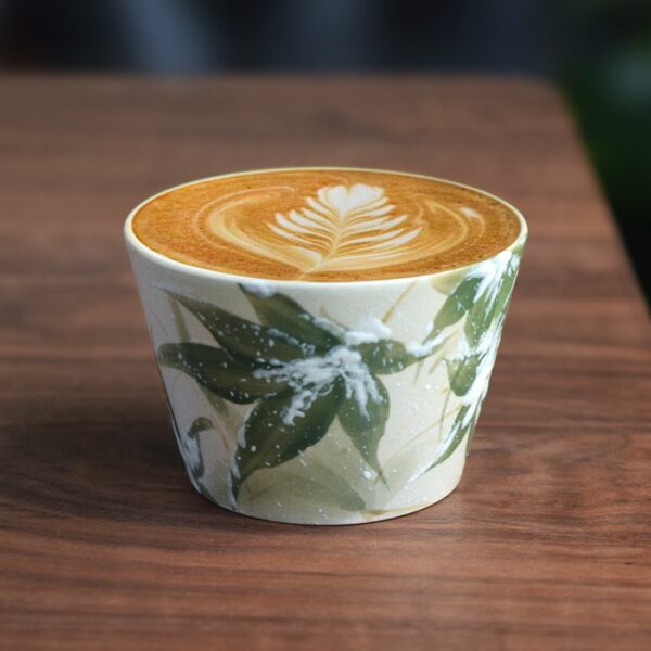 Hand-painted bamboo ceramic cup with floral latte art, rounded shape and soft glaze finish