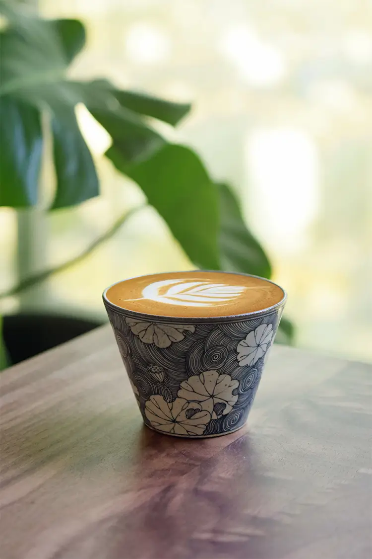 Traditional handmade coffee mug features a blue-and-white lotus pattern that brightens any office space.