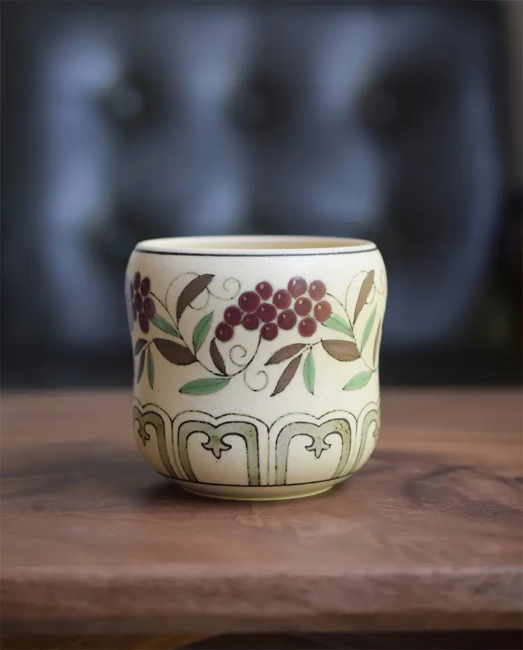 Traditional handmade tea cup showcases hand-painted grape vine motifs, perfect for tea lovers.