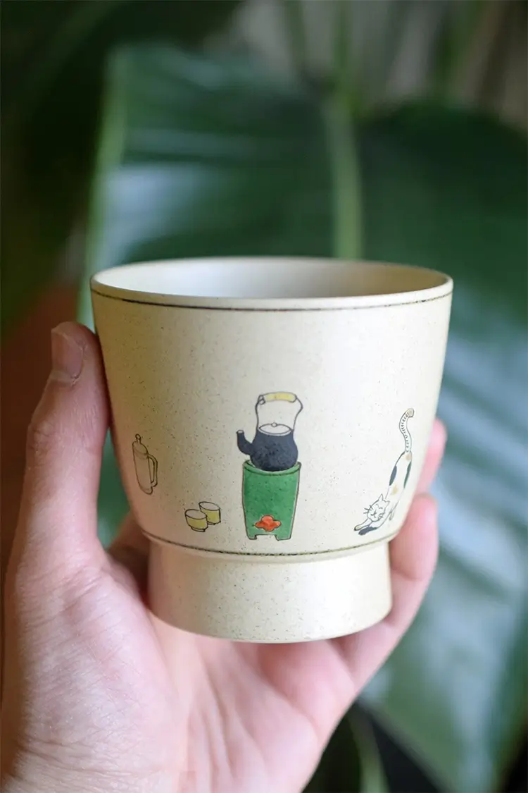 Vintage ceramic coffee cup features a cute illustrated design, adding charm and warmth to your office drinkware