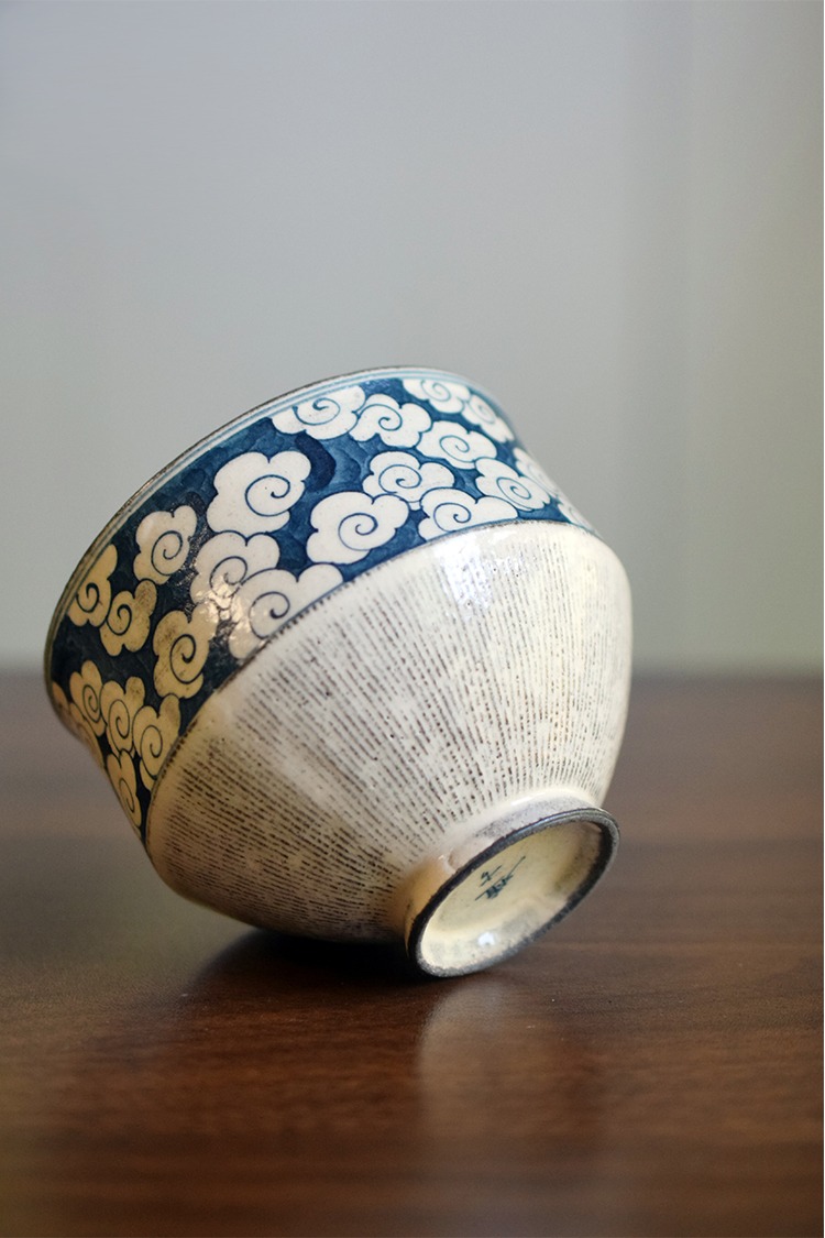 Close-up of vintage ceramic coffee cup base with circular foot, smooth glaze transition, and handcrafted texture