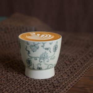 Vintage ceramic cup with lychee texture placed on table, designed for café use.