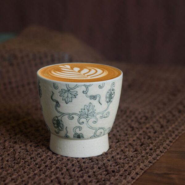 Vintage ceramic cup with lychee texture placed on table, designed for café use.