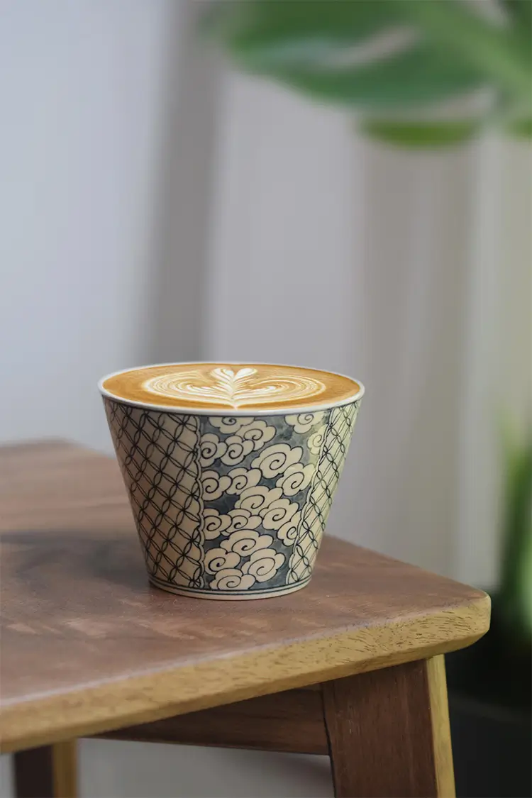 Handcrafted blue and white ceramic coffee mug with cloud motifs, ideal for daily use.