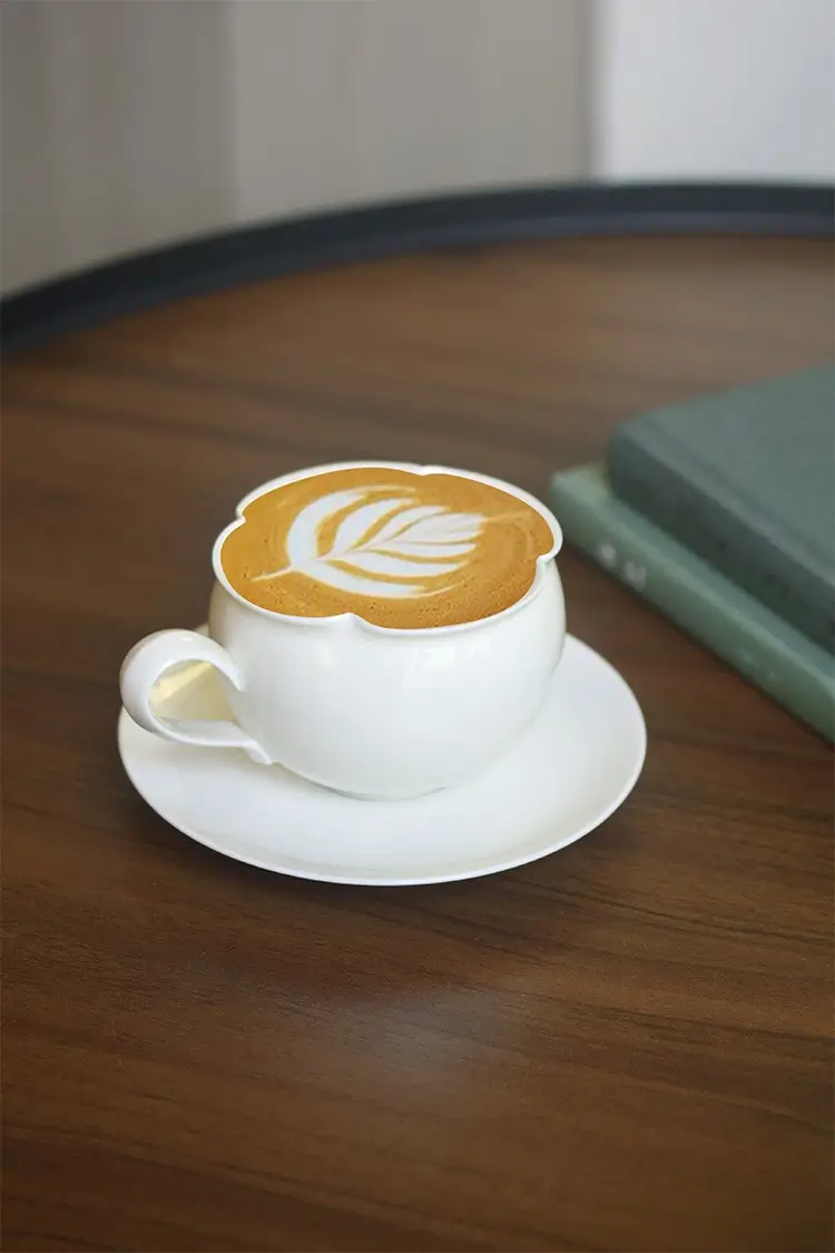 Handcrafted latte cup and saucer set with flower-edge design, perfect for custom weekend coffee rituals.