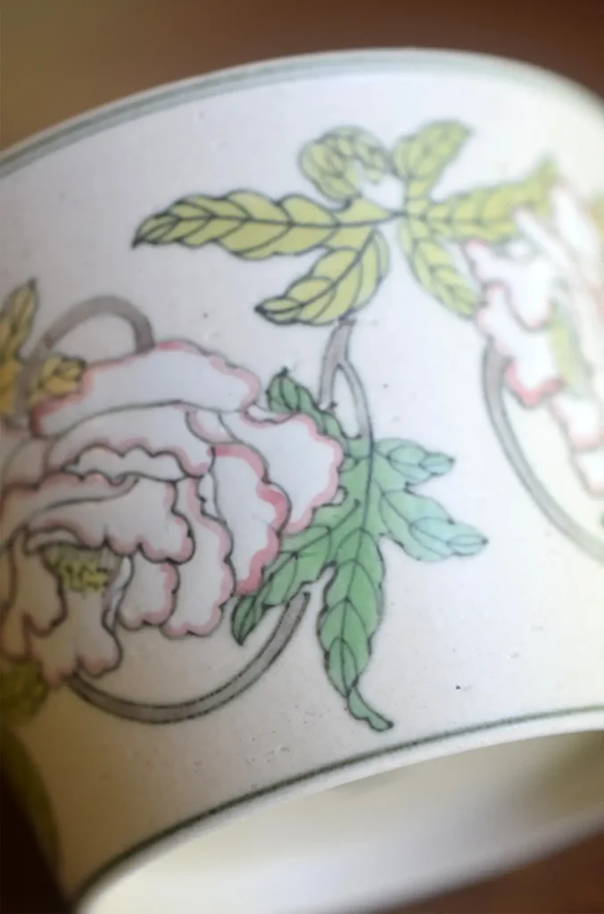 Hand-painted peony ceramic cup highlights traditional craftsmanship through intricate brushwork and natural texture.