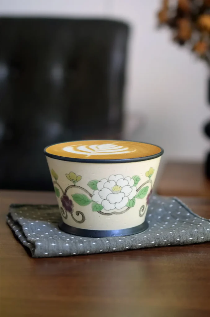 Handmade ceramic mug features hand-painted camellia design blending traditional Chinese charm with modern drinkware.
