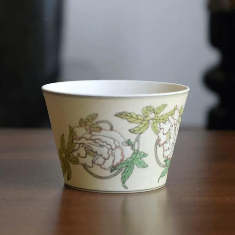 Handmade ceramic cup showcases traditional peony painting, perfect for enjoying tea or coffee.