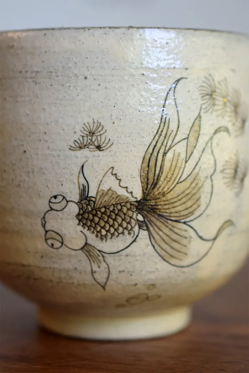 Custom ceramic cup features hand-painted goldfish in traditional blue and white style