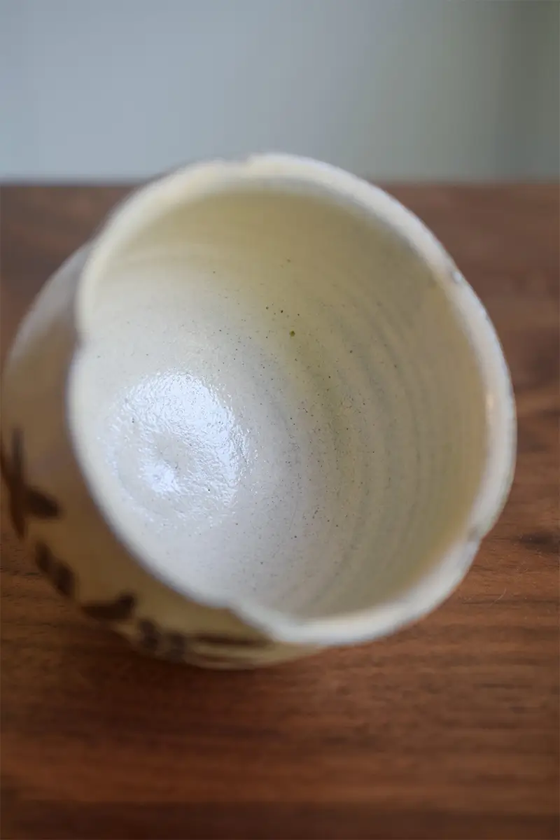 Custom Japanese ceramic cup with visible hand-throwing marks inside, showcasing traditional craftsmanship and unique character.