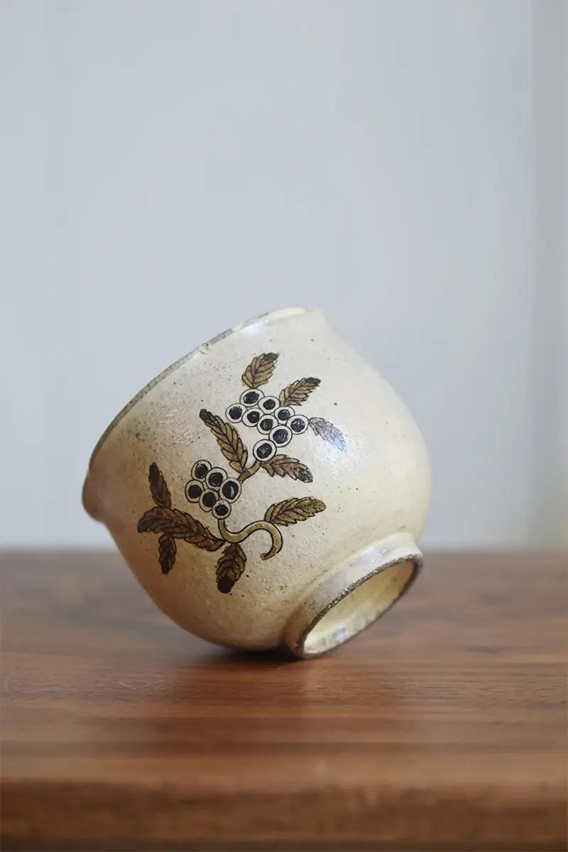 Hand-painted ceramic coffee mug with a ring-foot design at the bottom, showcasing traditional craftsmanship and elegant detail.