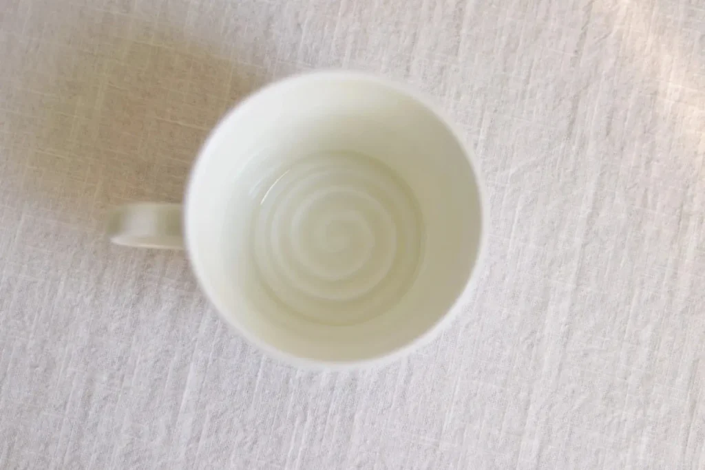 Handmade ceramic coffee mug featuring inner wheel-throwing lines that highlight its artisanal process