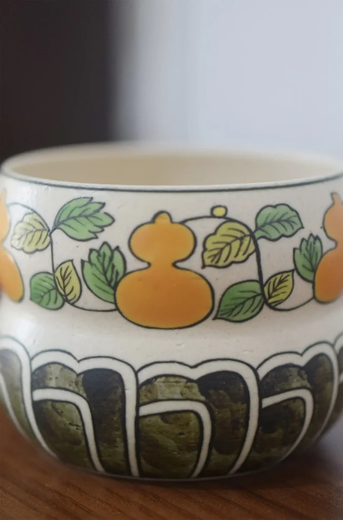 Close-up of underglaze painting on handmade gourd motif ceramic tea cup.