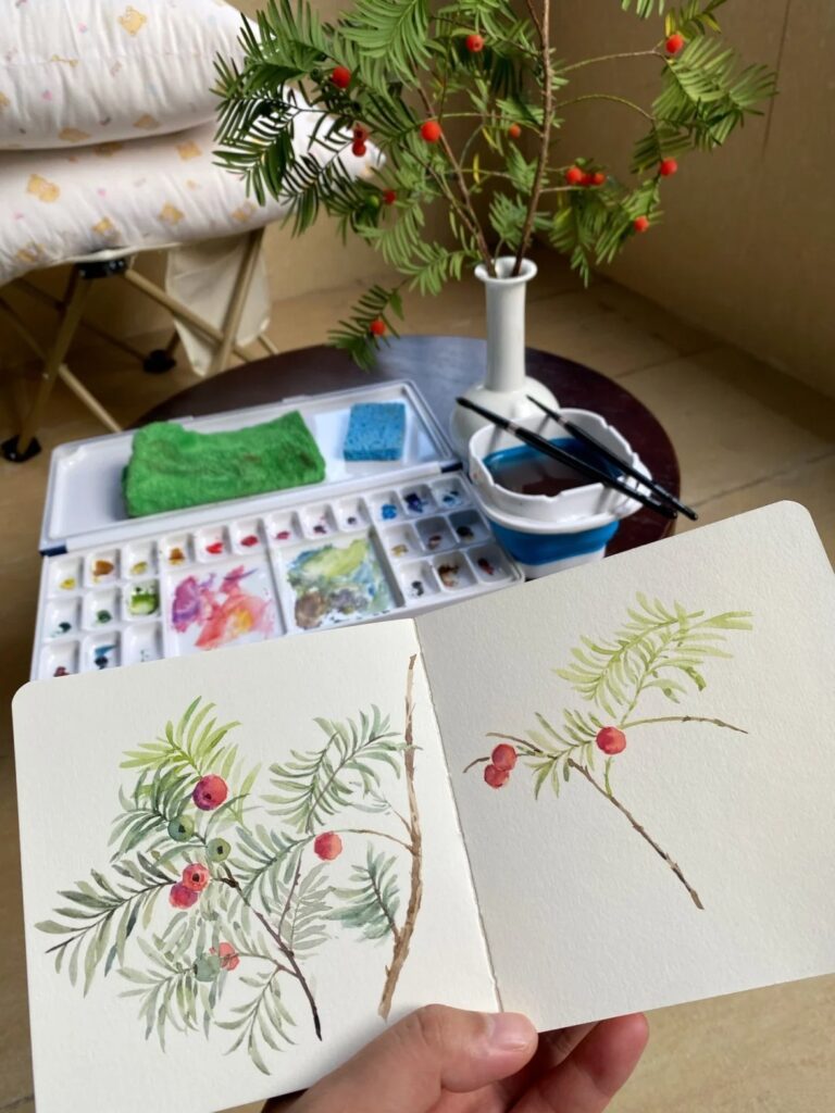 Artist sketching floral design from a real flower for ceramic decoration