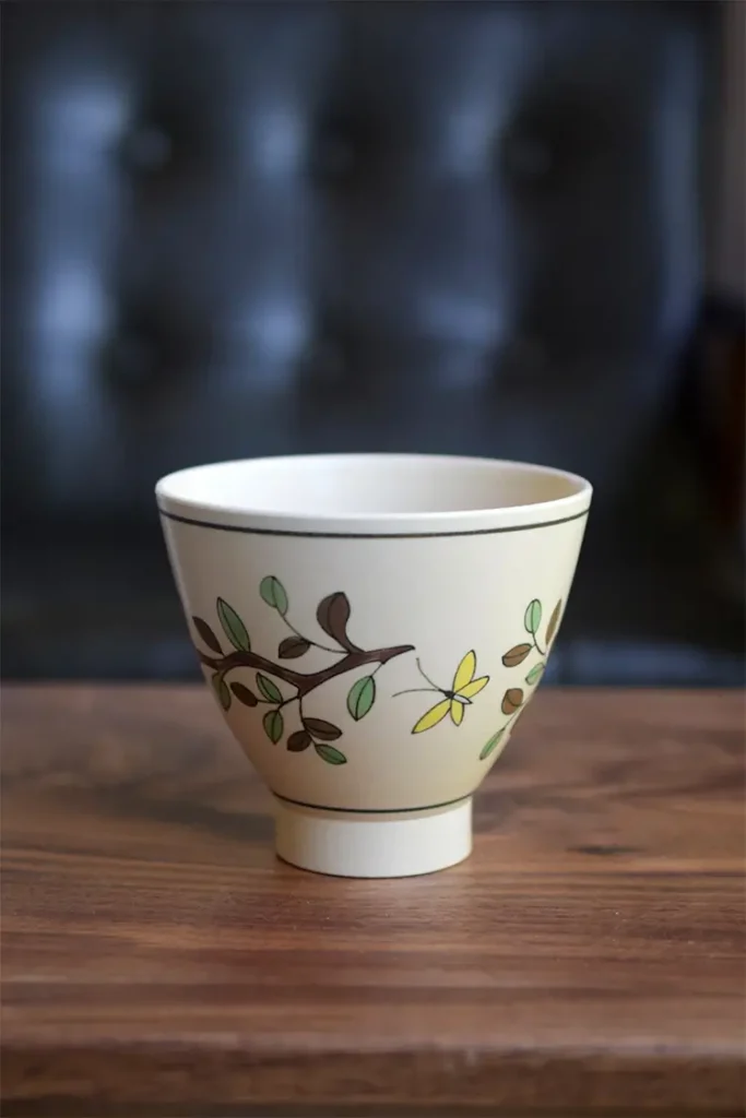 Back view of a ceramic coffee mug featuring a hand-painted underglaze camellia design, highlighting the intricate craftsmanship and detail.