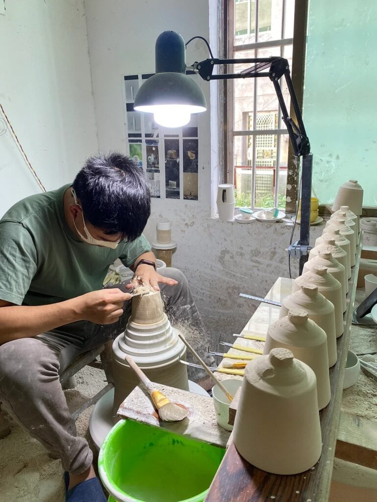 A Peonyceramics artisan carefully hand-trimming a ceramic cup on the pottery wheel